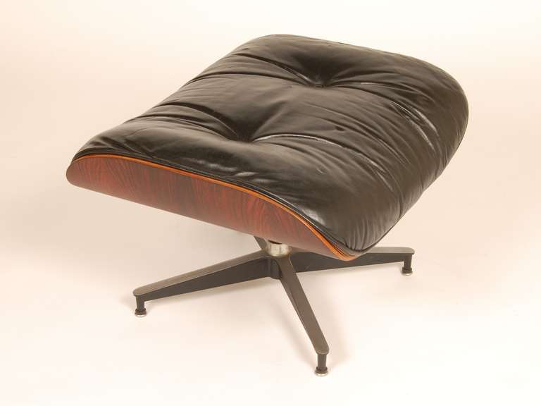 Rosewood and black leather ottoman designed by Charles and Ray Eames and produced by Herman Miller, circa 1970's.