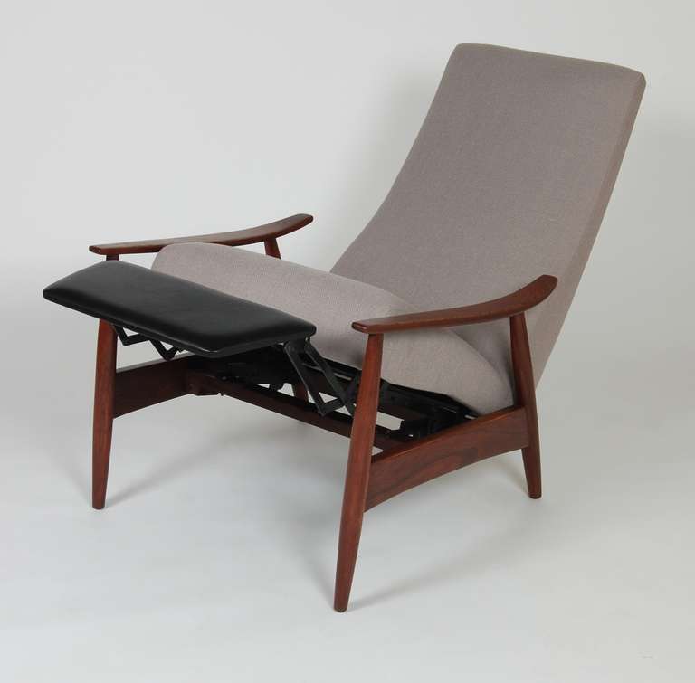 Milo Baughman design for James Inc., a three stage recliner, newly upholstered with a leather foot rest. The frame has a rosewood wash finish and is labeled.