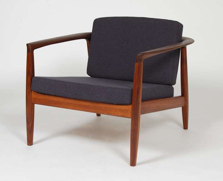 Folke Ohlsson design for Dux  sculptural armchair.  The arms consist of a single continuous sweep from front to back with a slant back. Richly colored solid refinished walnut frame, new foam, upholstery and pirelli webbing.