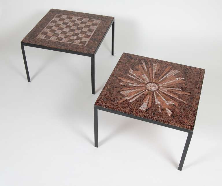 Pair of glass mosaic tile side tables with wrought iron frames, one is a sunburst abstract pattern and the other is a game board. The glass mosaics are a blend of rich root beer browns.