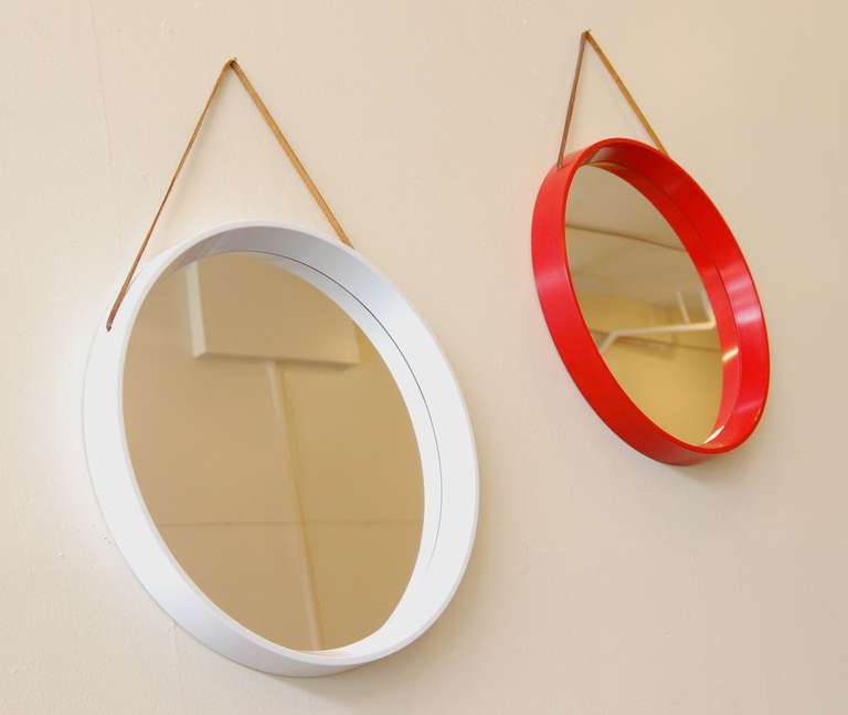 Pair of circular mirrors by Th. Poss' EFTF of Copenagen, Demark. The mirrors attach to the wall via a leather tether. The frames have a beveled edge on the inside, slightly squared off at the top edge and sides.