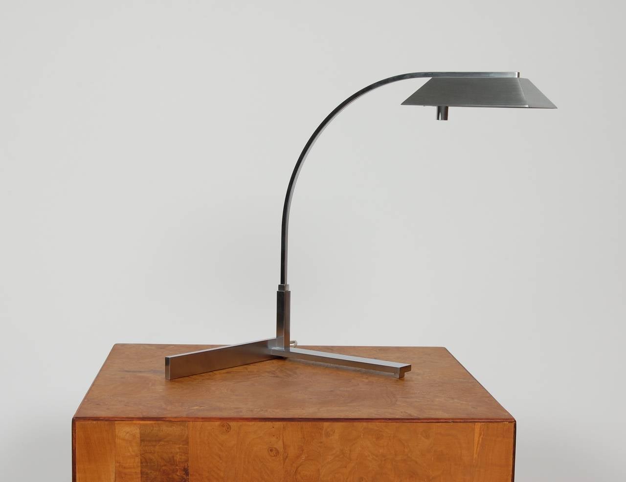 Brushed nickel finish 1970s era Casella desk lamp with a swinging lamp arm that moves from right to left on a V-shaped base. The shade is a tapered rectilinear form with an adjustable halogen light. Casella lamp is a company that is well-known for