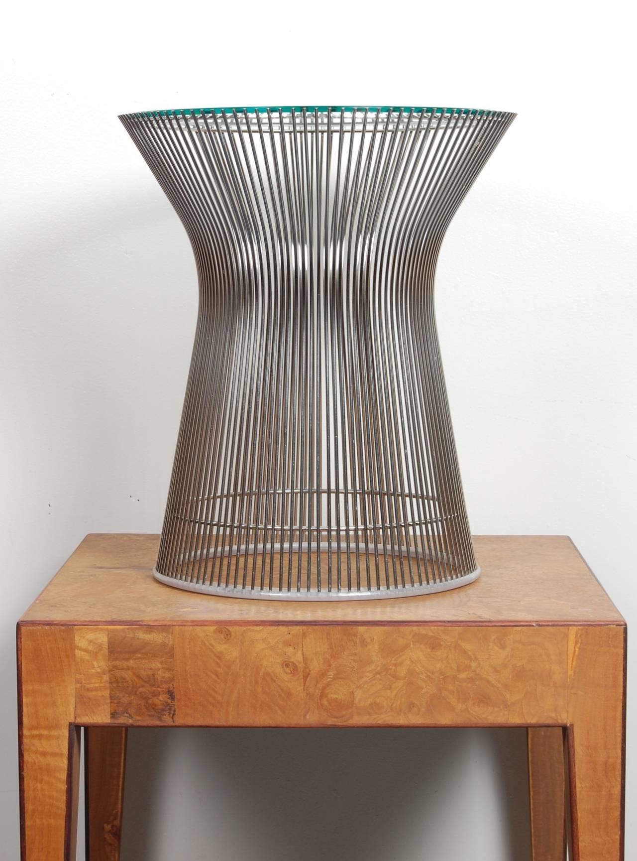 Nickel-plated wire bodied side table by American Architect Warren Platner for Knoll furniture. Atop the hourglass shaped welded wire frame is a circular inset glass top. The array of wire rods in its construction creates an interesting visual