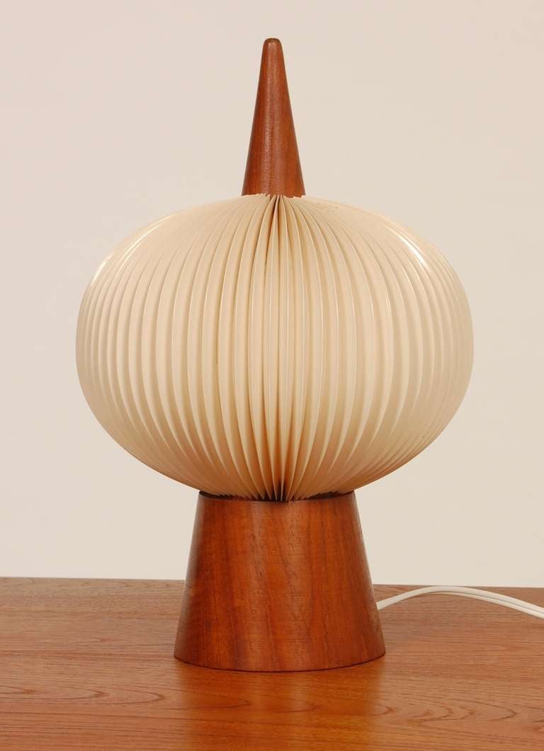 Conical form table lamp with accordion fold shade. Teak body with the shade being a flexible plastic. 