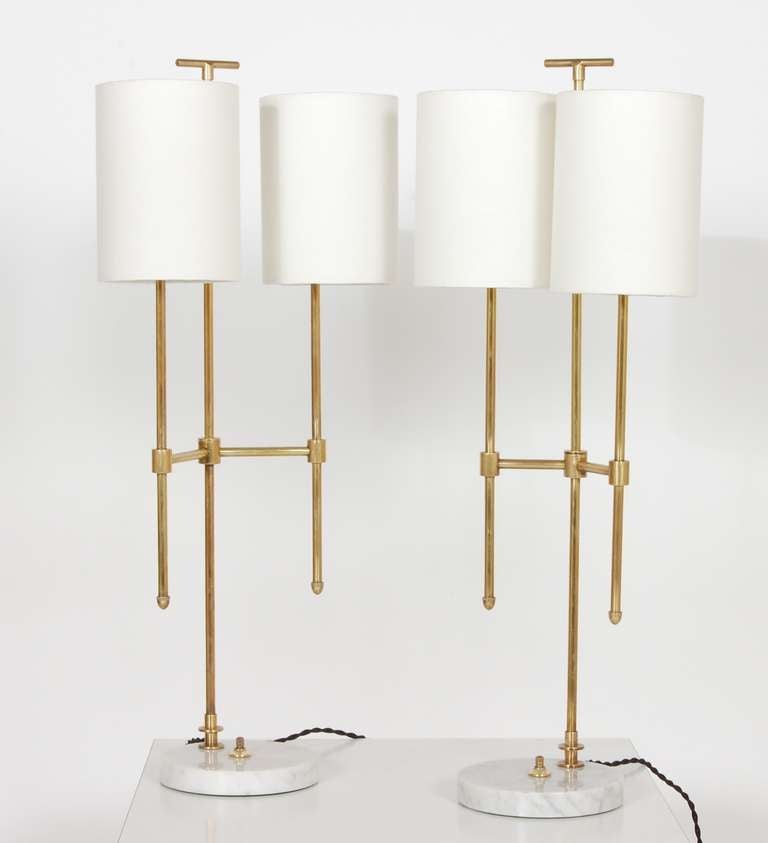 A pair of two-armed Italian table lamps with brass bodied, marble bases and new custom made linen shades. This is an asymmetrical set, being that the arm length is different in relation to one another, with the shades on, 12.5
