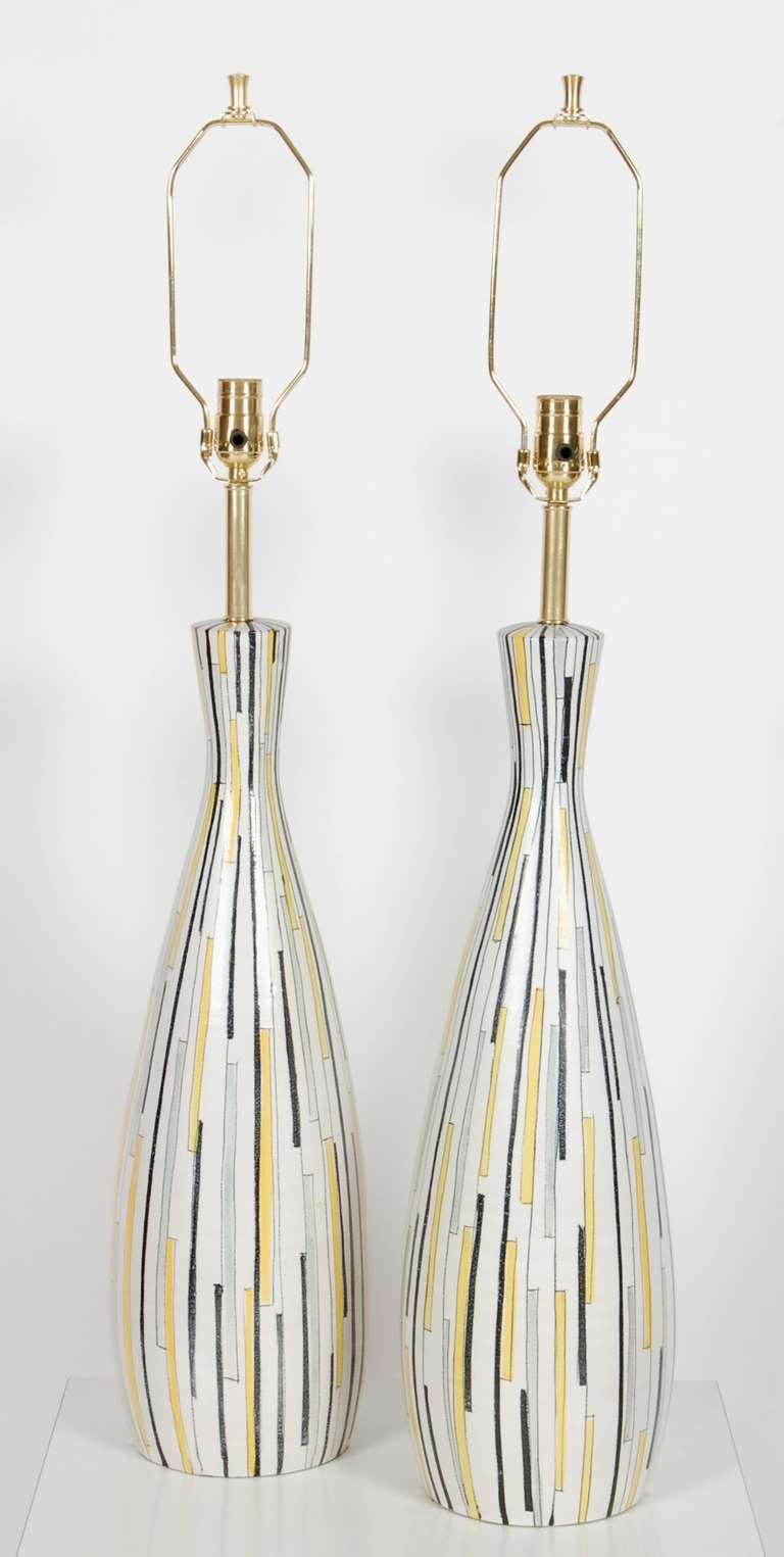 Pair of Italian ceramic table lamps by Bitossi for Raymor with an glazed abstract pattern on the body of the piece, signed Italy on the bottom of each possibly an Raymor design.  All new wiring and electrical components which includes a three way