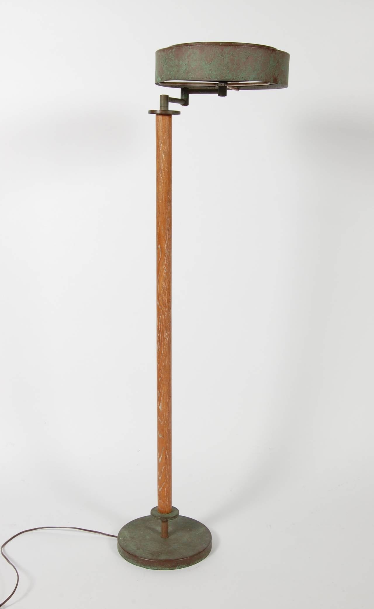 A early 1940s production Walter Von Nessen floor lamp, with its beautifully patinated metal work and aged oak upright. Trademark Von Nessen design swing arm and metal shade with both top and bottom opaque white glass diffusers. Professionally