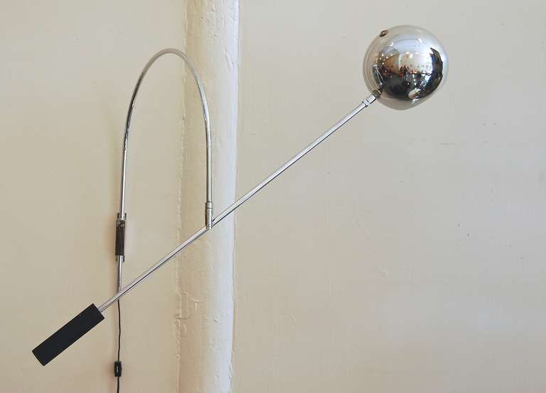 1970s, vintage wall-mounted lamp by Robert Sonneman, the radial wall-mounted arm swings back and forth and the straight-arm with the chromed globe shade and cast metal counterweight can be adjusted in an upward or downward manner.