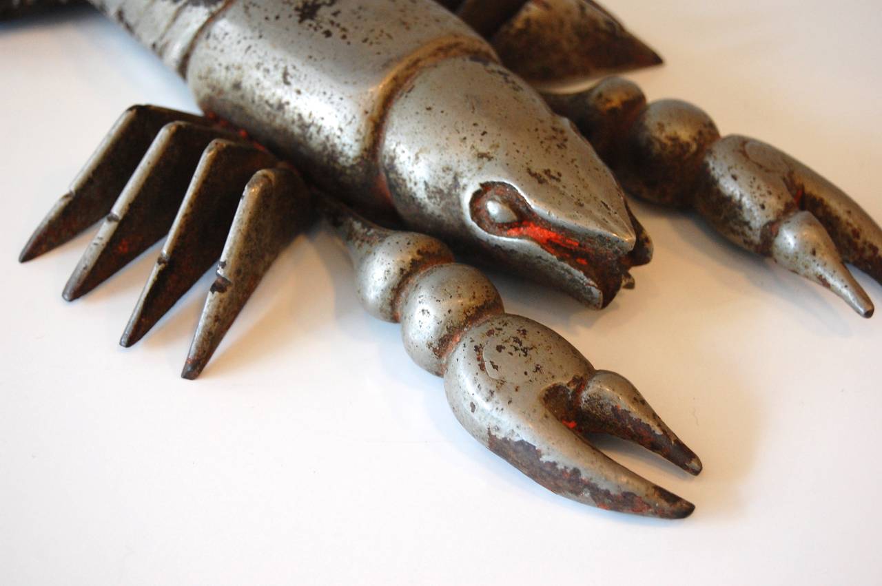 1930s-early 1940s solid cast iron with patinated chrome finish stylized sculpture of a lobster with articulating front claws. An interesting object from the machine age period of design.