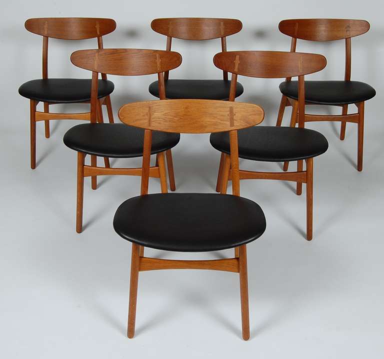 Early Hans Wegner CH-30 dining chairs, newly reupholstered in aniline dyed leather. A timeless design with their graceful backs exposed joinery and the curved back to leg form. Branded on the bottom of the seats Hans Wegner / Carl Hansen & Son,