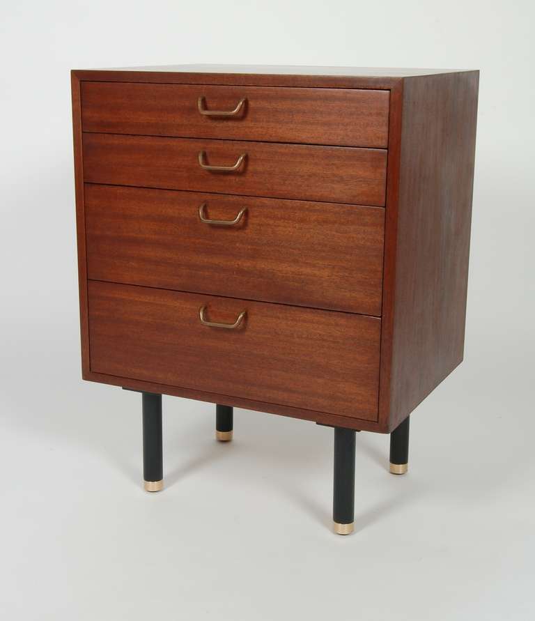 Compact Mahogany four drawer cabinet designed by Harvey Probber, black legs capped in bronze. Two shallow top drawers and two fuller bottom ones. Newly finished in a rosewood wash with the label residing in the top drawer.