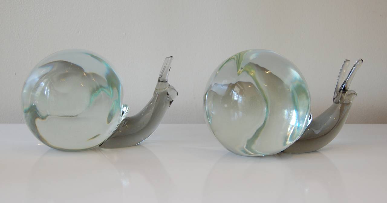 Pair of large Murano glass snails, the body consists of a pale blue smoke colored glass and the shells are clear with a faint green tint due to the thickness of the glass. Can either be used as standalone sculptures or as bookends due to their