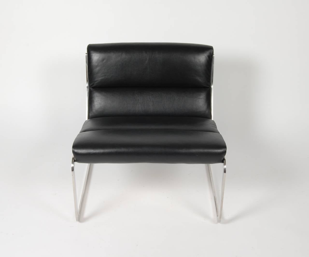 1960s vintage Cantilever lounge chair newly reupholstered in a glove soft black leather with a polished stainless steel frame. Having exceptional quality in the level of construction and design, the solid stainless steel frame is designed to flex