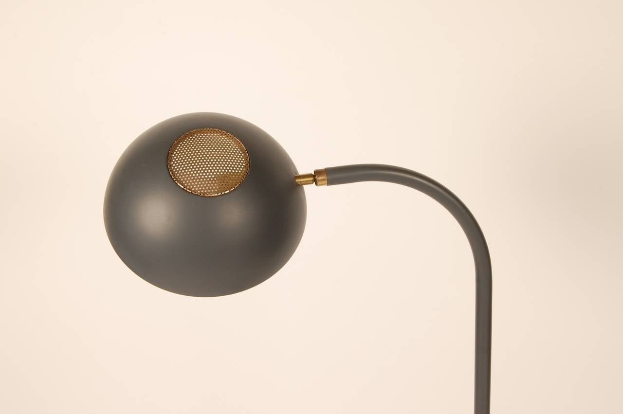 Lightolier floor lamp in a dark grey with brass accents, the lamp head has a pivot joint that allows for a wide range of movement to adjust the lighting. Beautiful original finish and rewired.