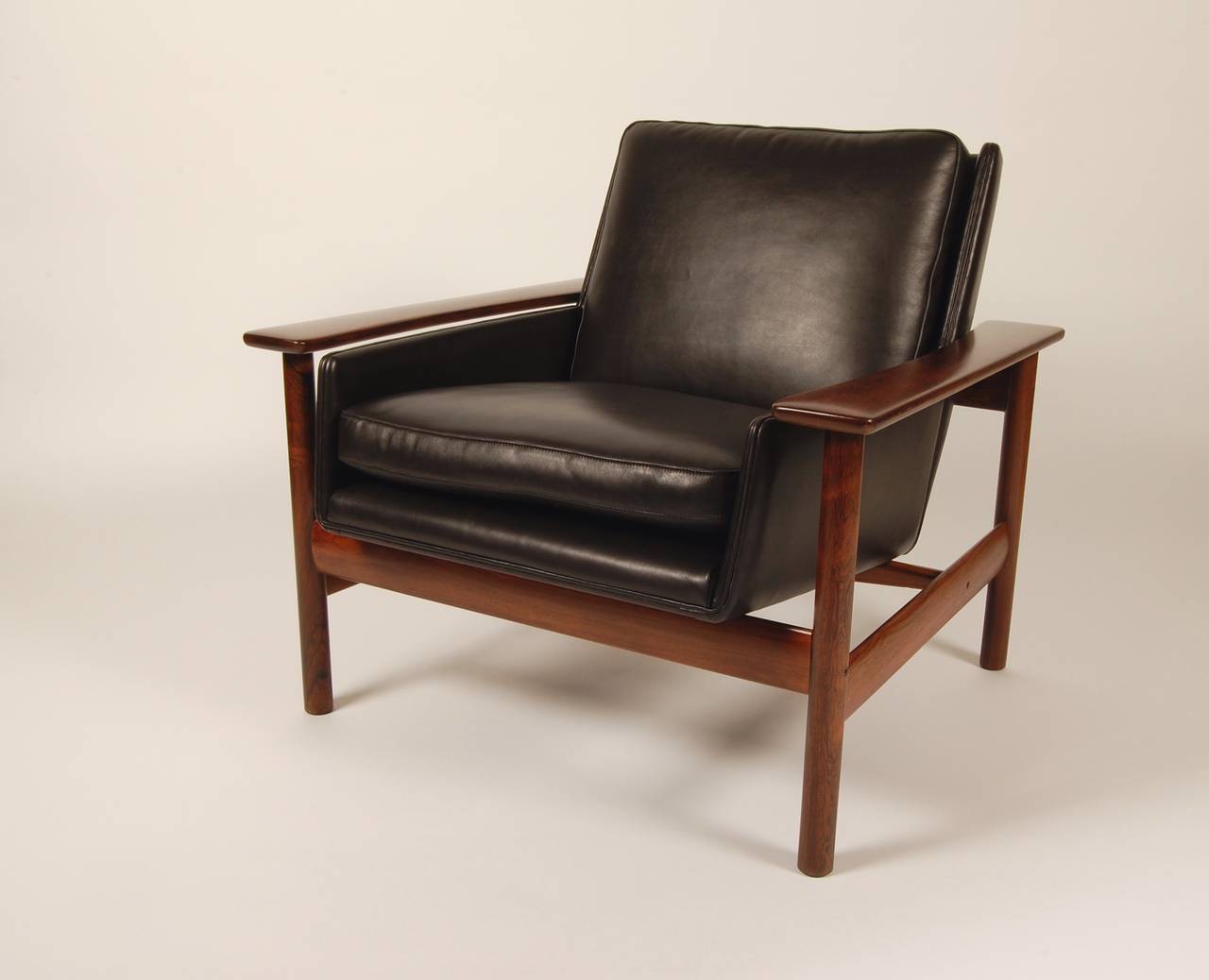 Rosewood and black leather lounge chair designed by Sven Ivar Dysthe for Dokka Mobler of Norway. The leather seat sits in the rosewood frame and is cradled by the sculptural paddle arms. Proffesionally restored to like new condition, using the