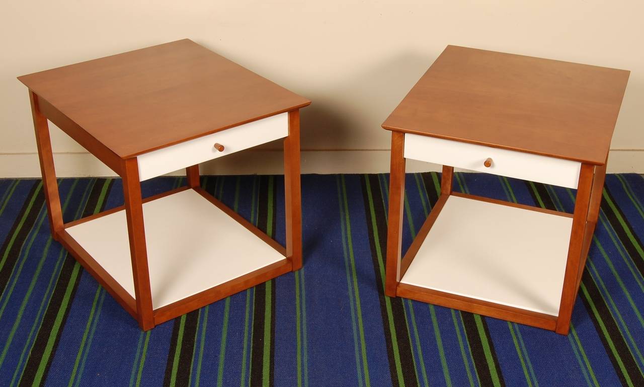 An early design by Milo Baughman are these night side tables for the Murray Furniture Company from the first half of the 1950s. Constructivist cube form with an off-white front drawer and bottom self. The drawer has a soft tapered wooden pull,