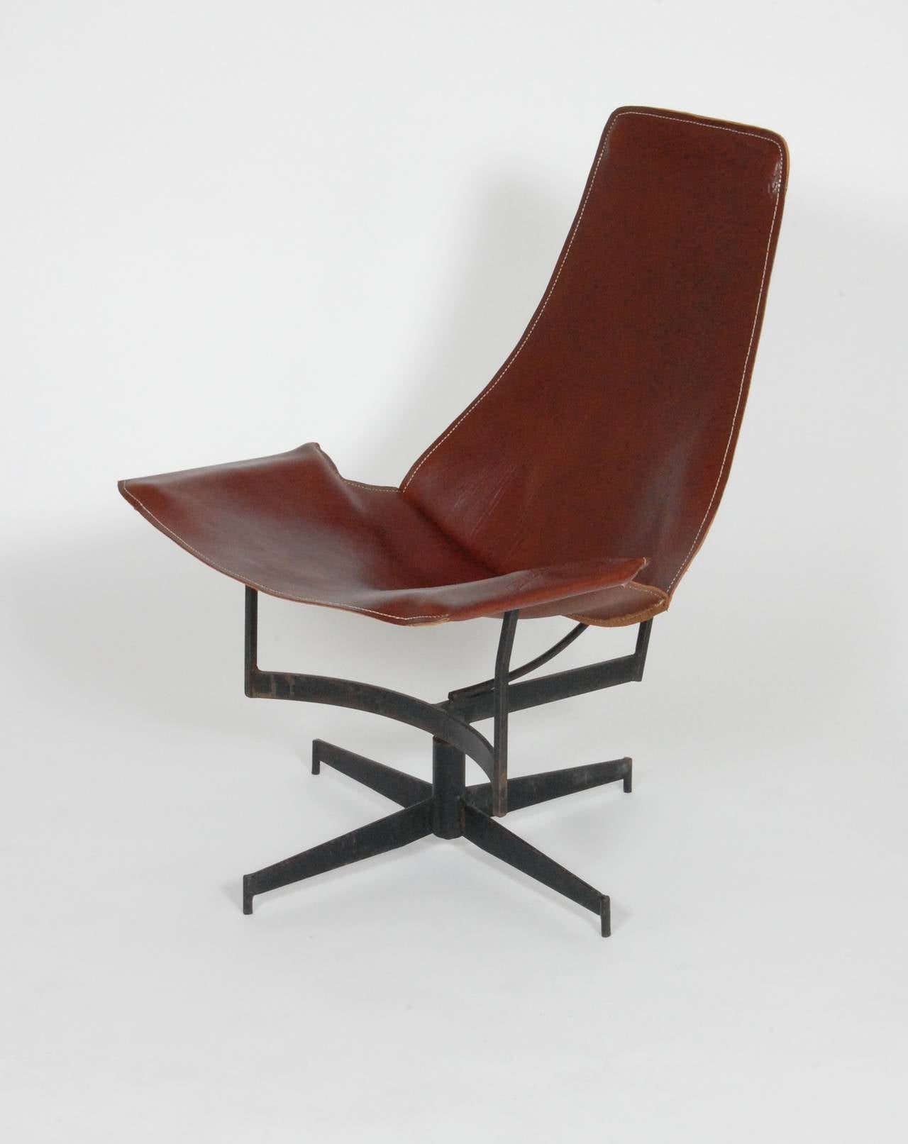 Designed by William Katavolos and manufactured by Leathercrafter of New York, this sling chair has a painted iron frame that swivels with a leather slip cover. A somewhat obscure design by Katavolos who is better know for his work with fellow