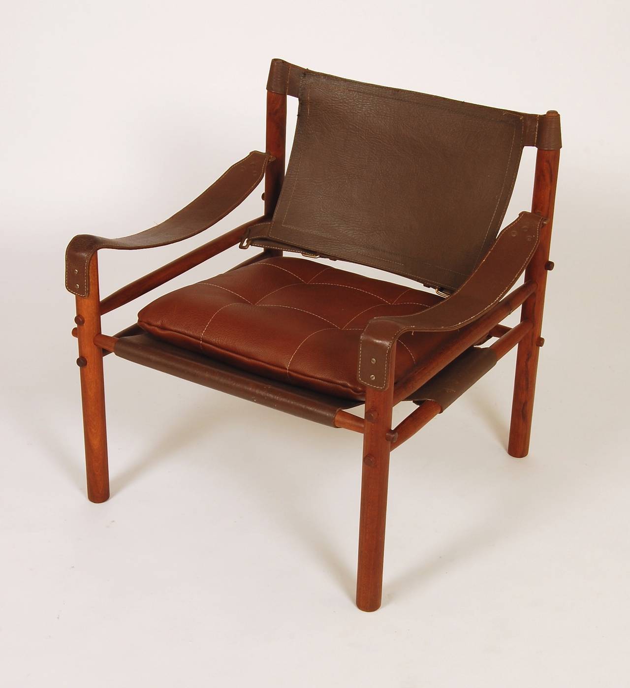 Safari chair by Swedish designer Arne Norell in a brown textured leather with a new cushion and a teak frame. The brass hardware has a soft patina to the finish.