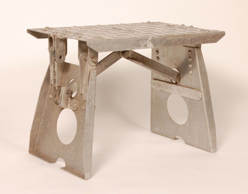 Industrial strength folding step stool used in airports for small planes. Two struts act as the support which are held in place by bronze pins, which then can be disengaged and folds into an ingenues compact form for storage and transport.