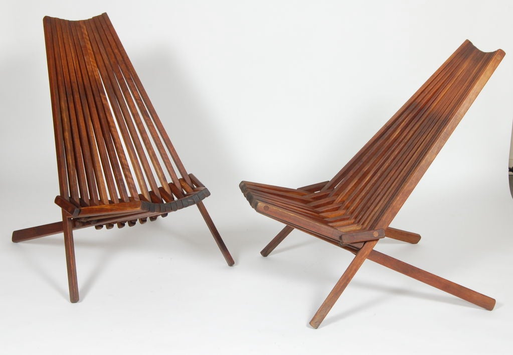 Wood slated folding lounge chairs, an interesting design approach for a comfortable and compact chair. Priced as a pair.