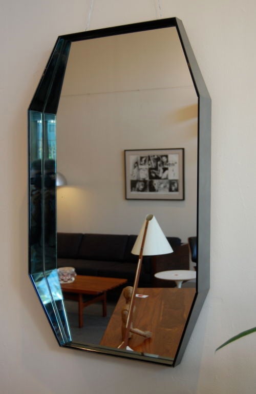 Octagonal shaped mirror having a slight grey blue tint to the mirror, the graduated metal sides has a brushed steel finish. Can be displayed either vertically or horizontally.