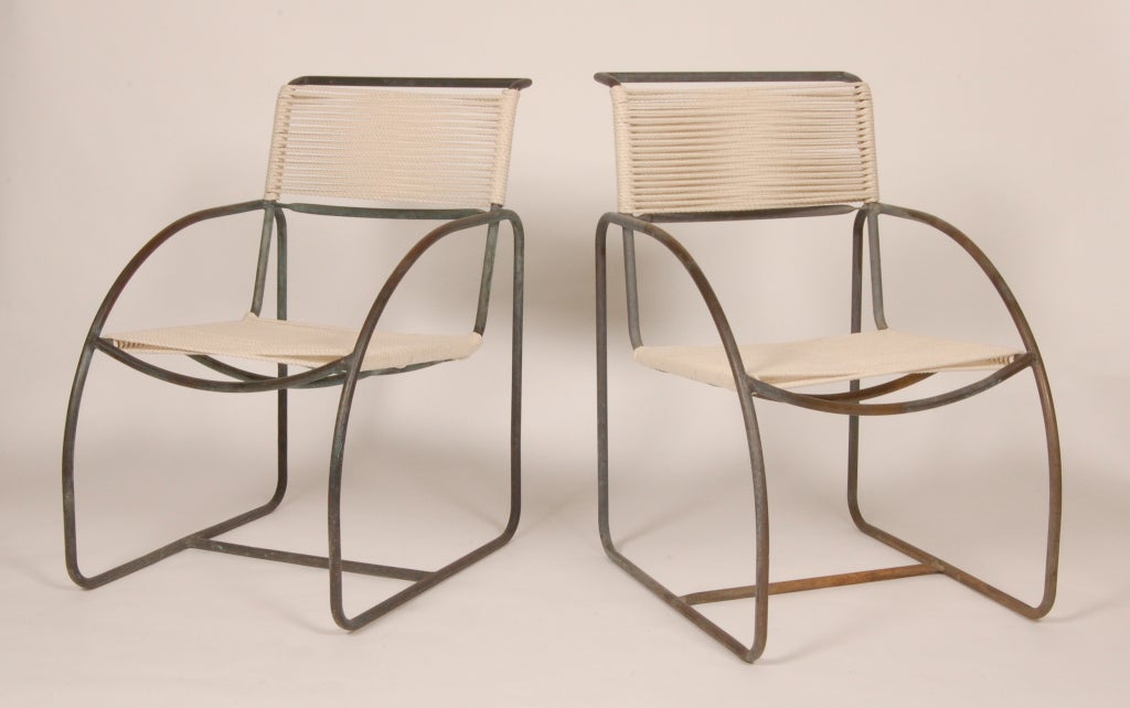 Patio arm chairs constructed of  bronze tubing and cotton yacht cord, having curved arms leading into the legs creating a rounded triangle on the side view. Designed for Terra by Kip Stewart and produced for only a very short period and with limited