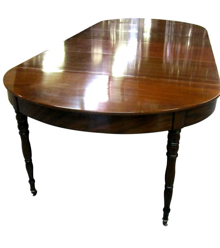 An exceptional French Empire Period oval dining table in Cuban mahogany, early 19th century, on turned 