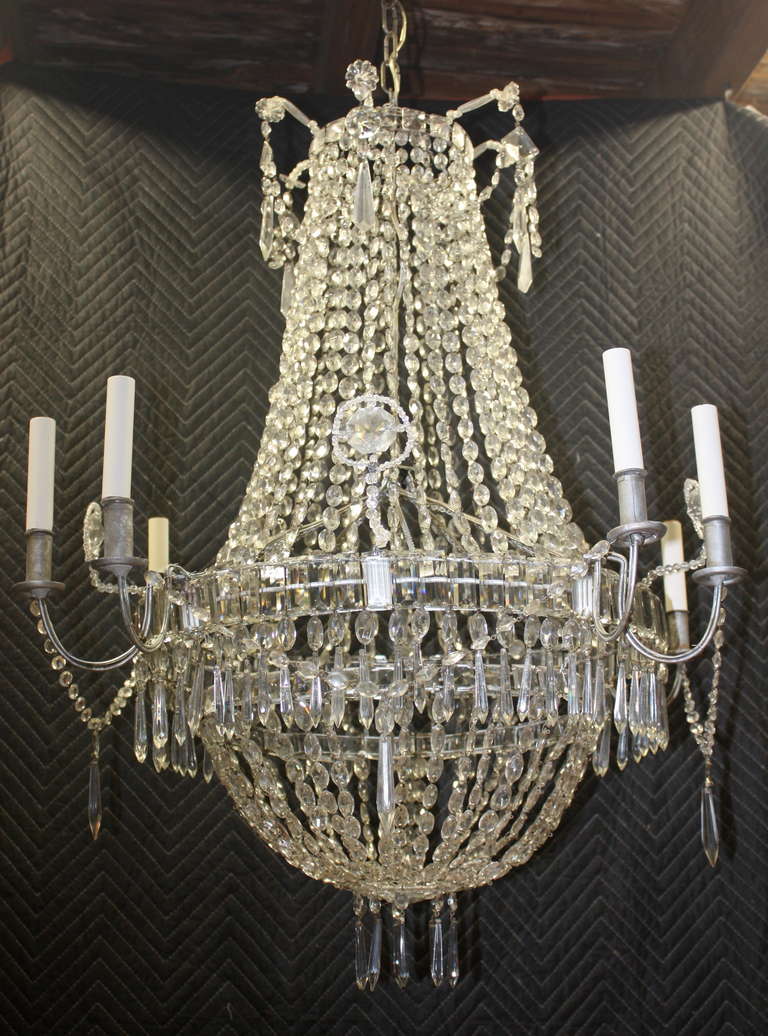 A French Louis XVI style crystal chandelier, circa 1900, having 8 tole arms, recently electrified, with over 1200 crystals and beads.