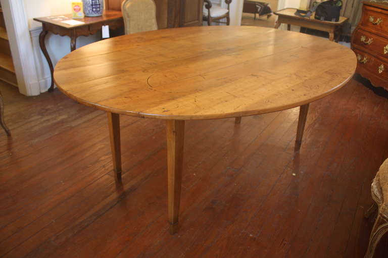 A wonderful French oval drop-leaf farm table in cherrywood, circa 1850, with tapered legs and pull-out leaf supports.  27