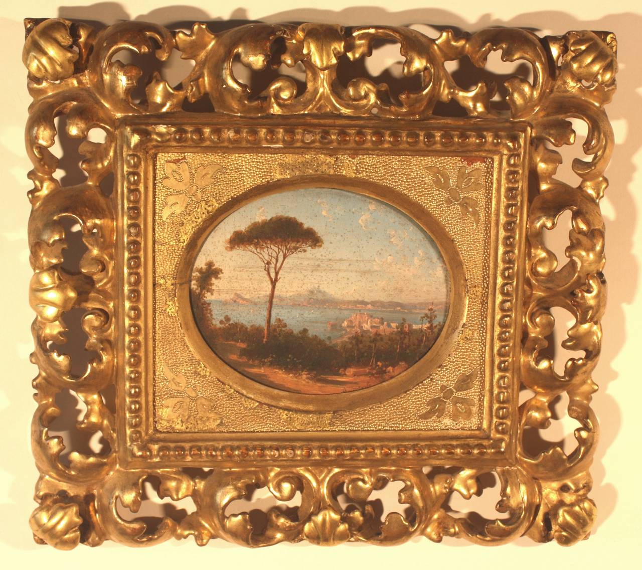 A mid-19th century Italian painting on board of the Bay of Naples, by Domenico Ammirato (1833-1890) circa 1850, signed lower right. The Baroque-style frame is nicely sculpted and gilded. Image size is 6" x 5" oval.