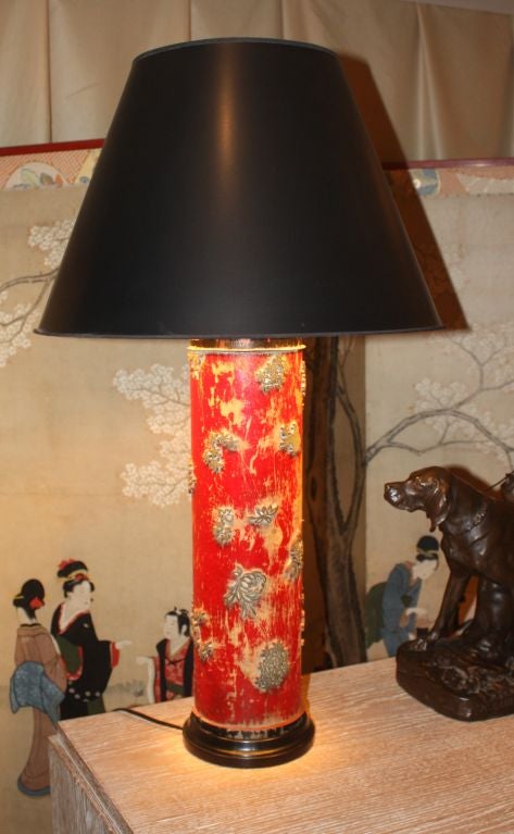 A colorful French fabric roller in painted wood with brass details mounted as a tall table lamp.  Brass cap, 3-way socket and ebonized wood base.
