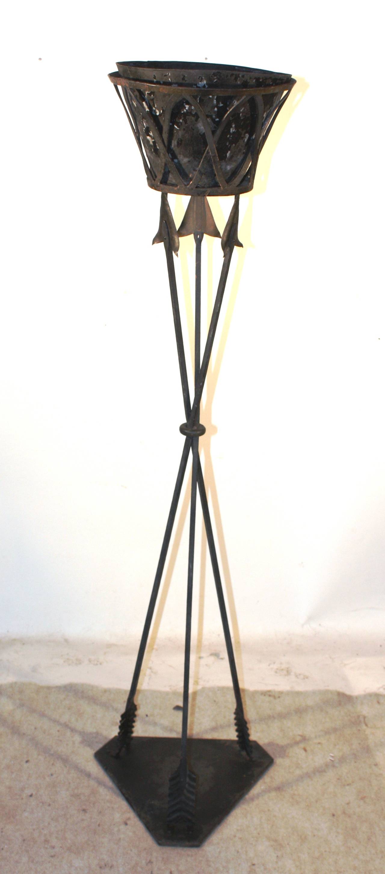 A decorative Empire style tole jardinaire, French, early to mid 20th Century, in the form of a wire basket on three arrows on a triangular base, retaining its original black painted finish and tin liner.
