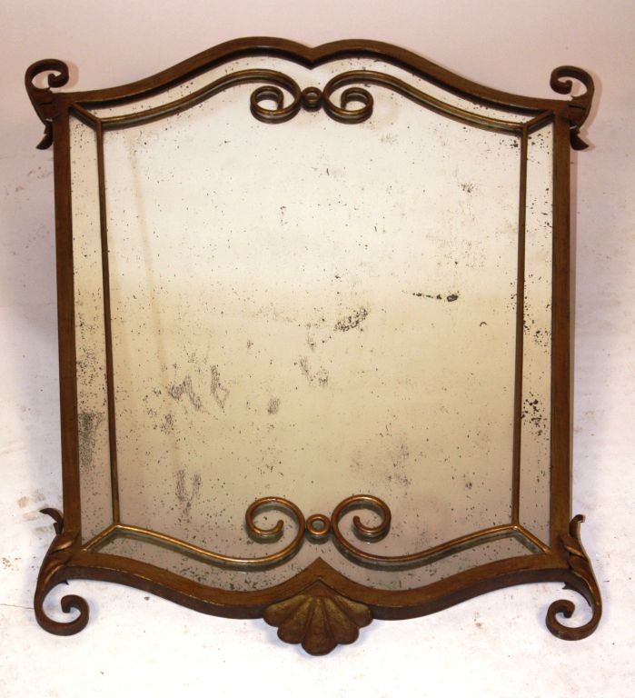 A nice gilt-iron mirror with original glass plate, with applied decorative scrolls and sunburst motif.