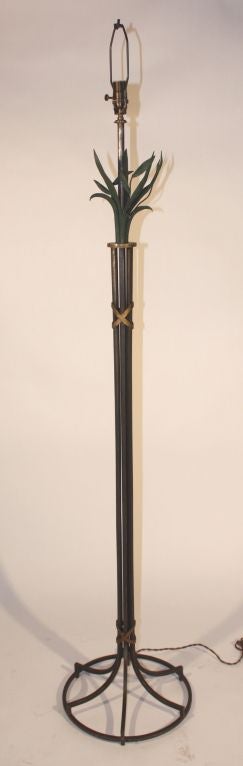 A decorative floor lamp in wrought iron and painted tole, French, circa 1940.