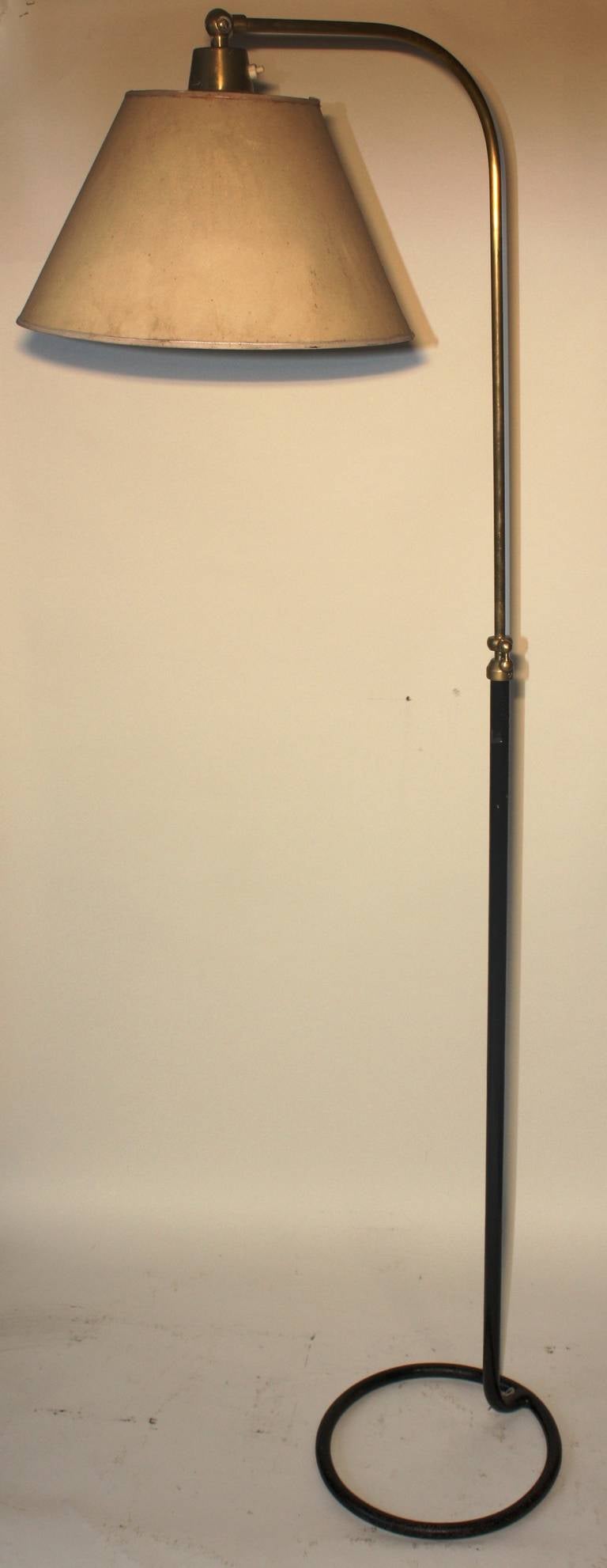 A nice Modernist Style floor lamp in the manner of Jean Royere, circa 1940, French, in tubular steel and brass with a circular base and hanging paper shade.