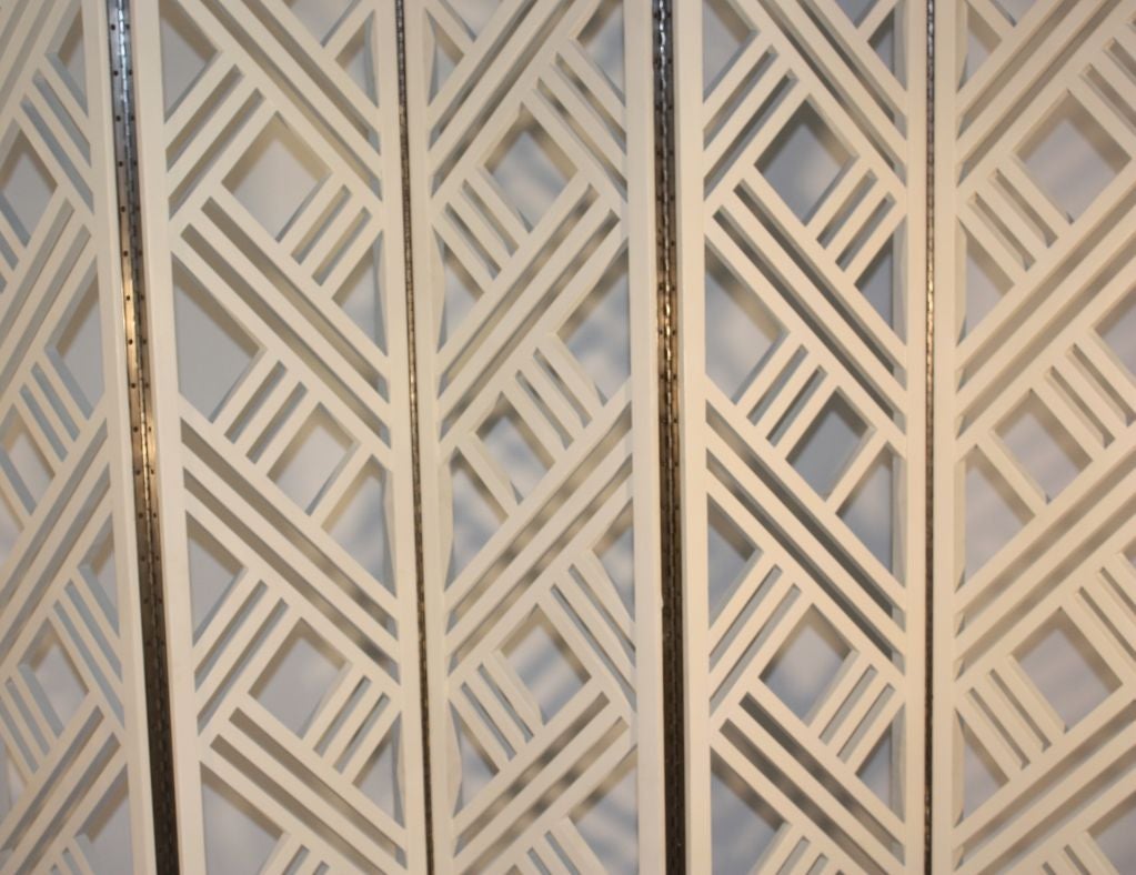 An early modernist 5-panel folding screen in cream painted wood with a geometric design.