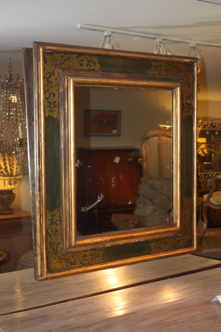 A large and decorative Italian Baroque Style mirror with old plate glass, circa 1850, the ebonized frame decorated with gold leaf.