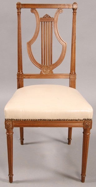 A nice set of Louis XVI style side chairs attributed to Jansen, in walnut with lyre backs and upholstered seats supported on turned and fluted legs.  Great to use with a card table.