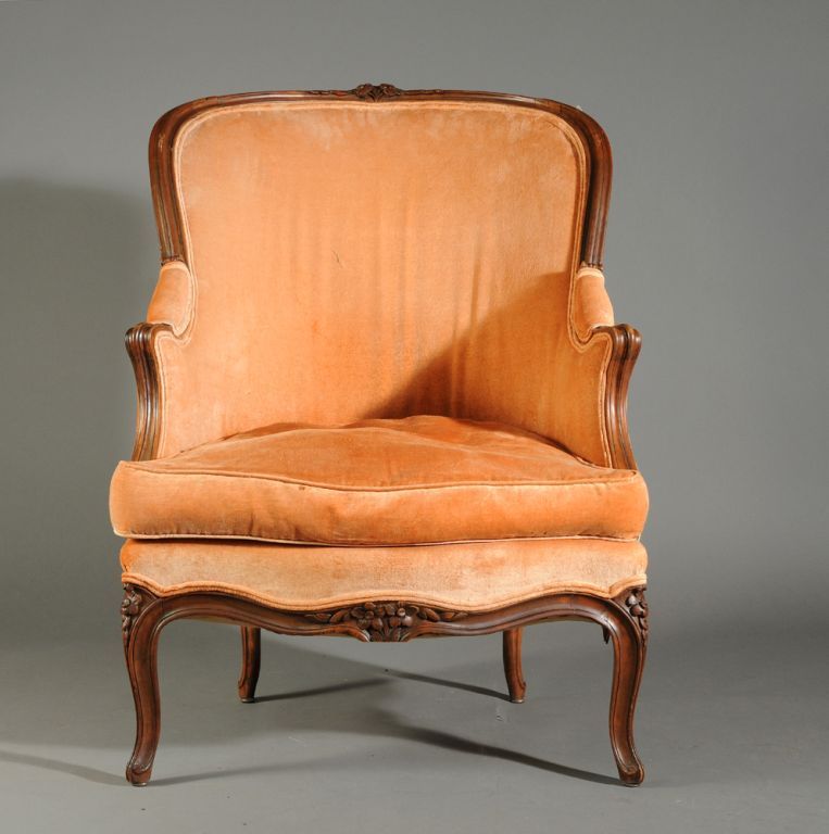 A beautifully carved and proportioned bergere cabriolle in walnut, French circa 1760, currently upholstered in salmon colored velvet.