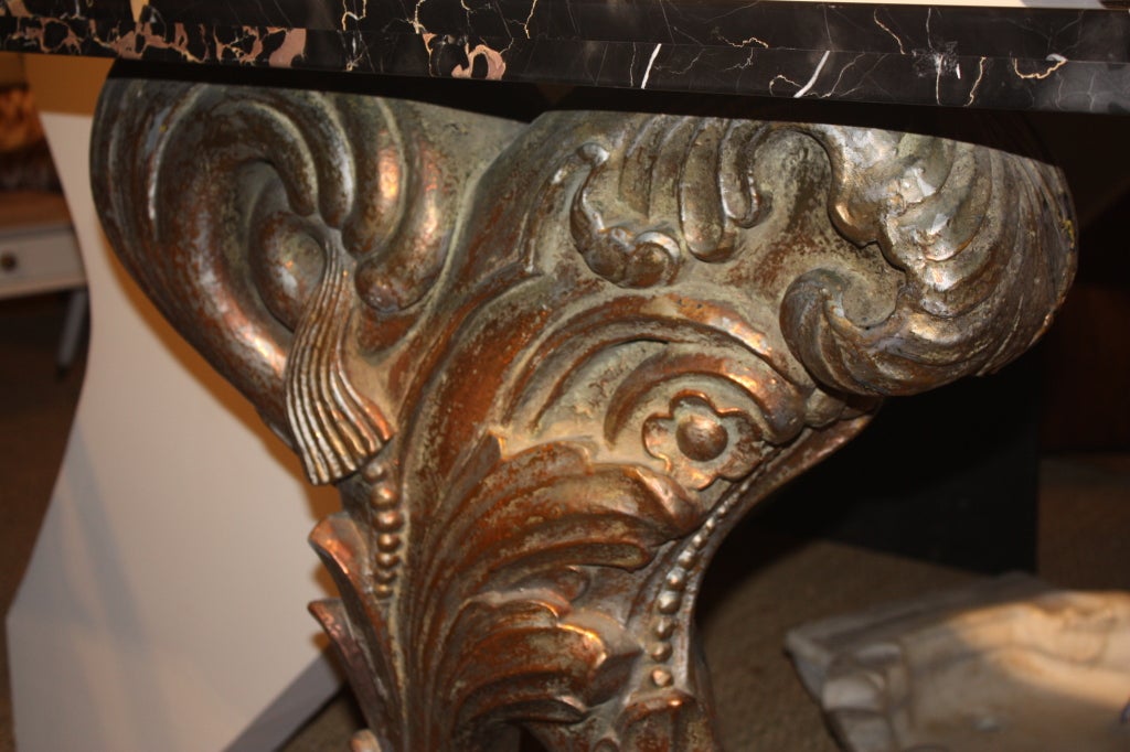 A Art-Deco period console table, attributed to Dorothy Draper, circa 1930, in copper and silver gilt over cast plaster with a black lacquer wood base and a verigated marble top