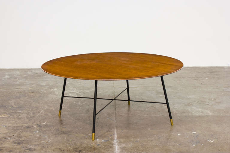 Ico Parisi circular coffee table, 1955.

Walnut-veneered wood, painted metal, brass.

Manufactured by Cassina, Italy.