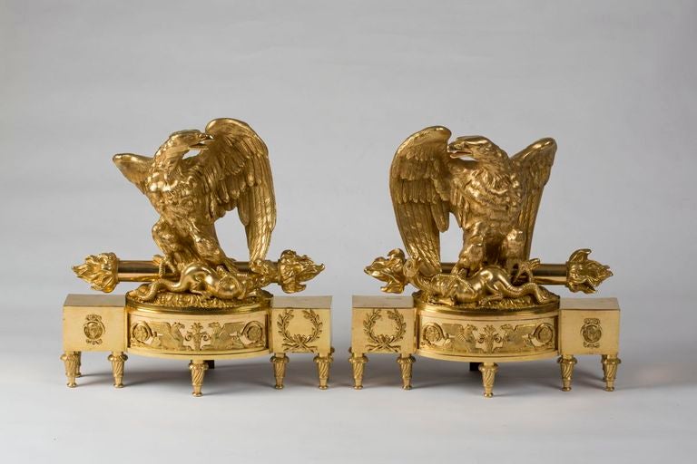 Ciascuna con un'aquila che regge una salamandra e una torcia, sollevata su un basamento decorato con sfingi e allori.
Modellato da Pierre Gouthière, originariamente realizzato per la grande galleria dell'Hôtel della Duchessa di Mazzarino nel 1781,