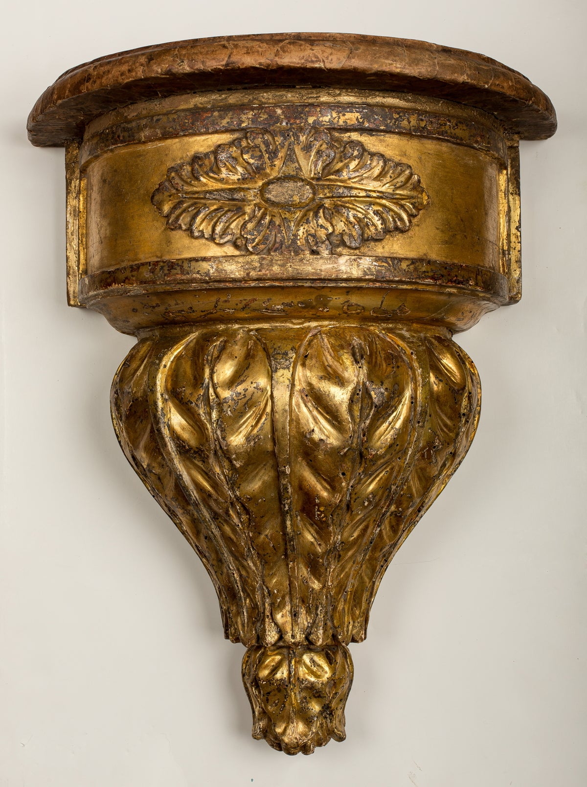 Each demilune shaped marbleized top above a conforming frieze decorated with a stylized leaf above a marbleized shelf.