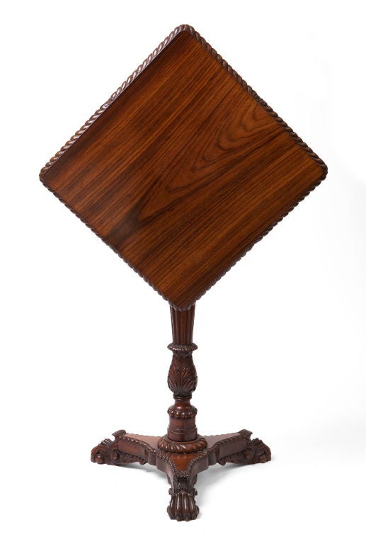 The rectangular top with a gadrooned edge tilting above a tapering gadrooned stem with a foliate baluster base‚ on a concave-sided triangular plinth ending in paw feet. Most likely colonial.