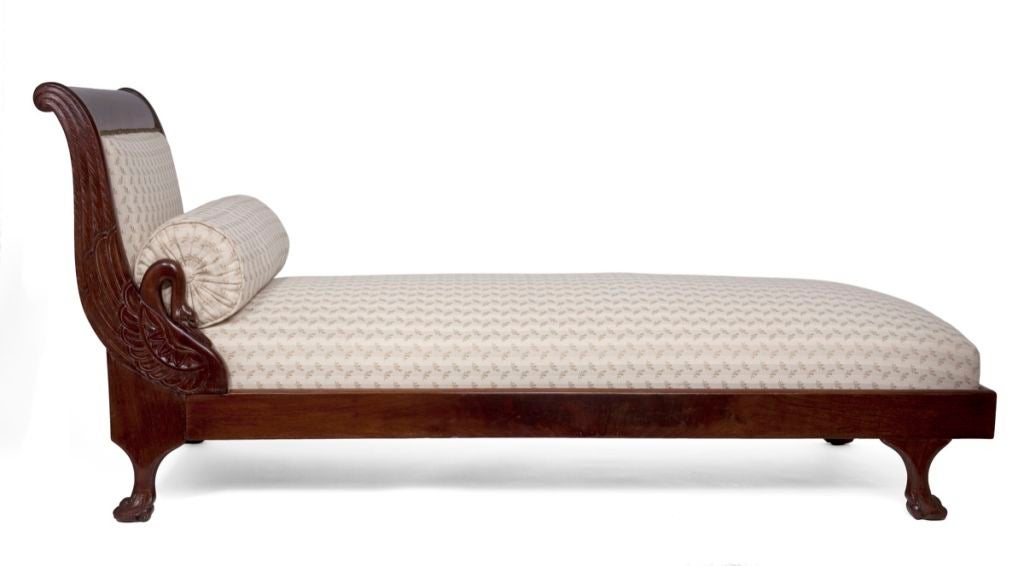 The padded headboard carved with swans‚ the headboard and the rails raised on paw feet.