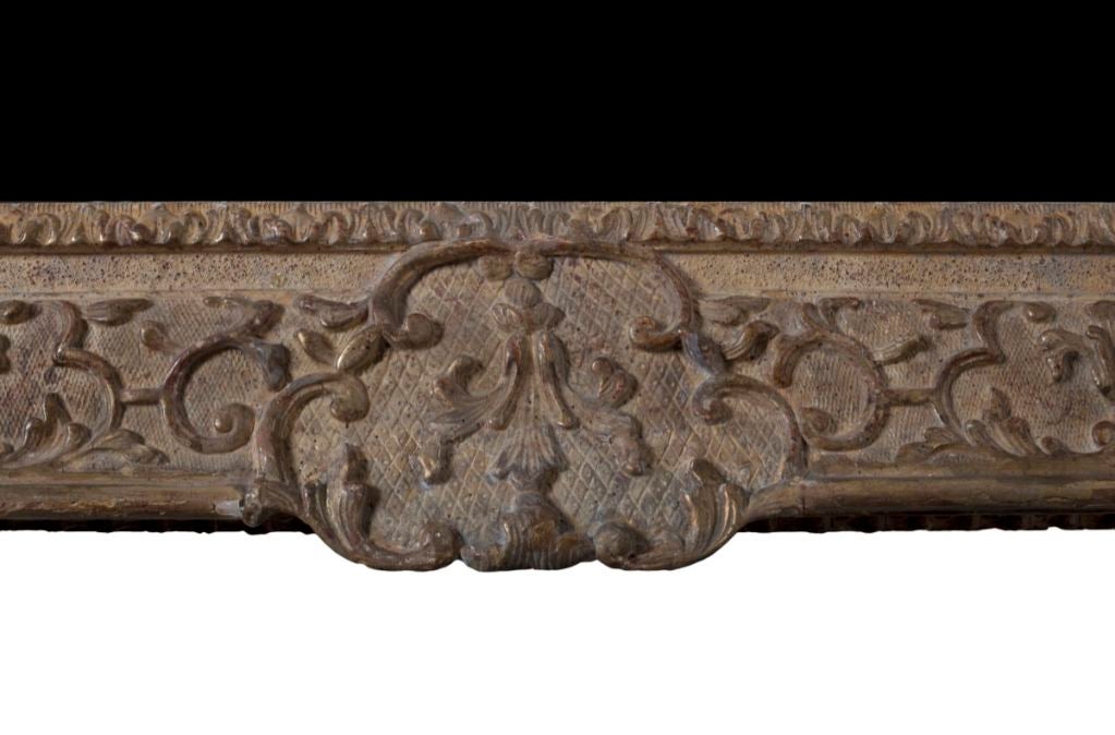 The modern mirror plate within stylized foliate carved borders.