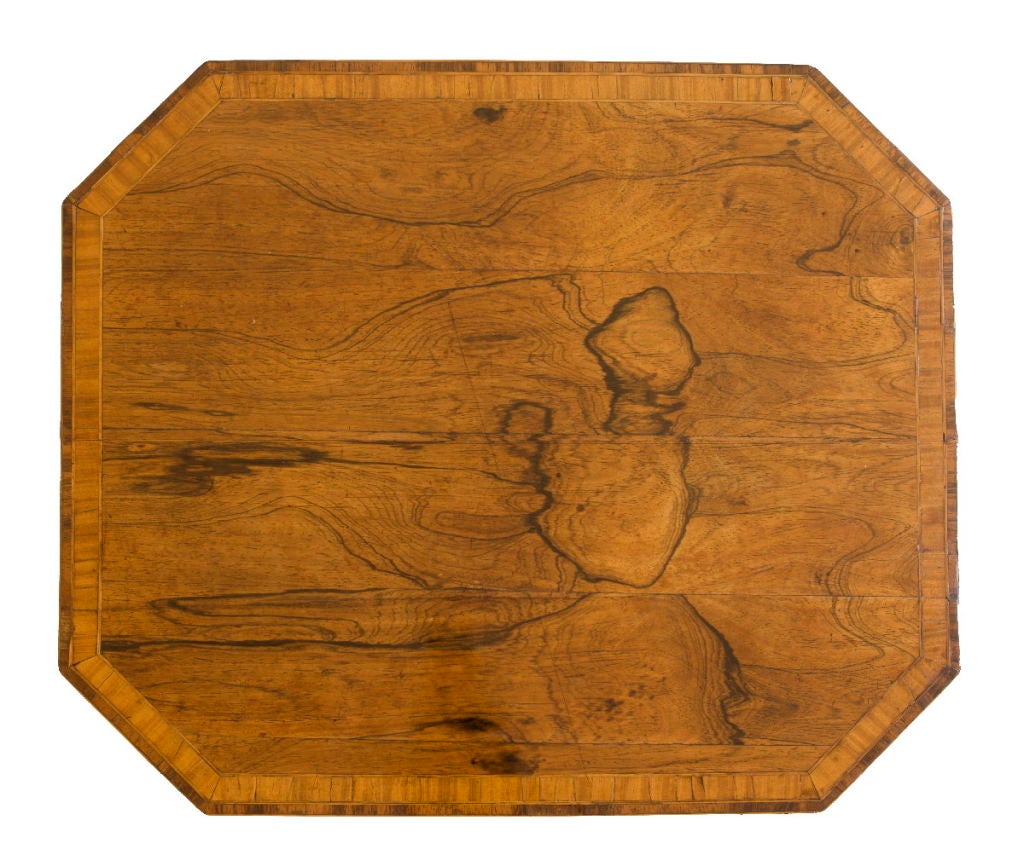 Die rechteckige Platte aus satiniertem Palisanderholz mit Querbändern und abgeschrägten Ecken befindet sich auf einem gedrechselten Baluster, der auf vier gespreizten Beinen steht, die in Rollen enden.