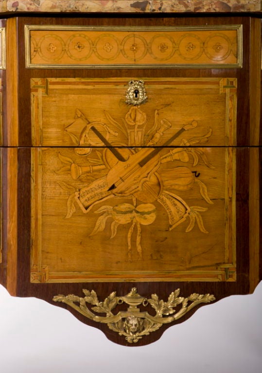 Timbrati Stumpff e Ohneberg. <br />
Il piano in marmo di breccia sagomato e con le orecchie, sovrastato da due cassetti con fregio geometrico in legno di raso e tre pannelli intarsiati in sansa. <br />
traversa con trofei musicali, sopra un