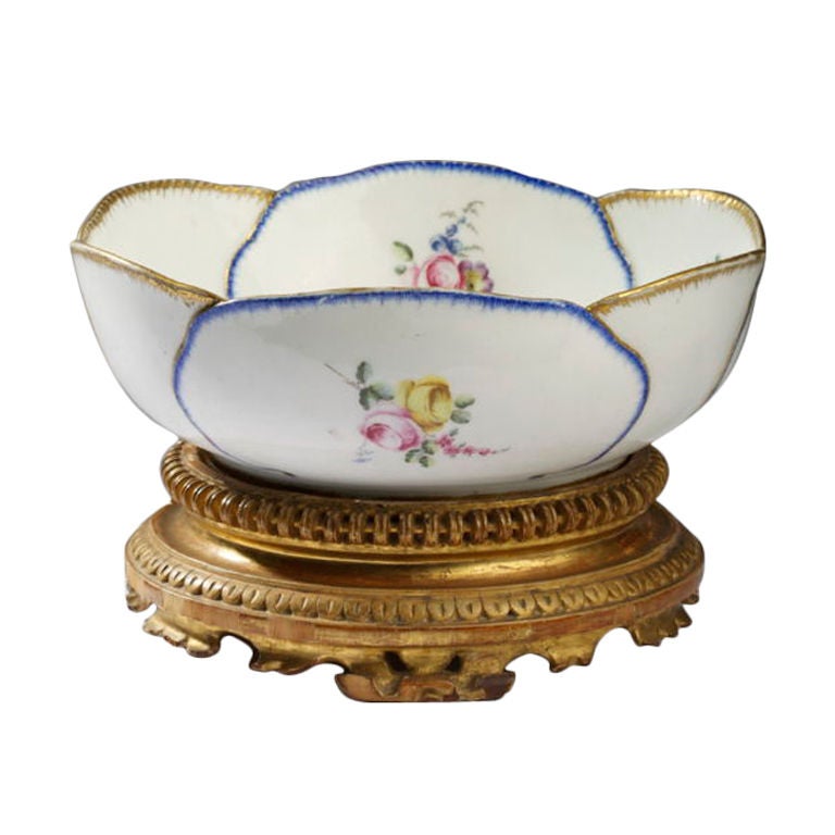 Painted in colors with loose bouquets and flower sprays within “cabbage leaves” enriched in gold and feathered in blue, within a scalloped edge, raised on a later giltwood base. The two blue interlaced L’s enclosing the date letter D (1756),