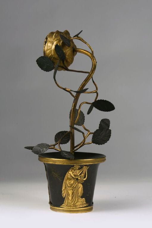 Modelled as a potted flower, the pot decorated with gilt bronze classical figures. With an 18th century English movement.